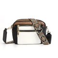 Juniper color block crossbody bag in black white and brown with gold-tone zippers and an ornate patterned strap