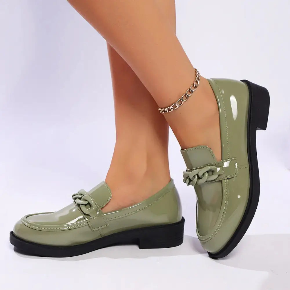 Olive green patent leather chunky loafers featuring a decorative chain-link strap and black sole
