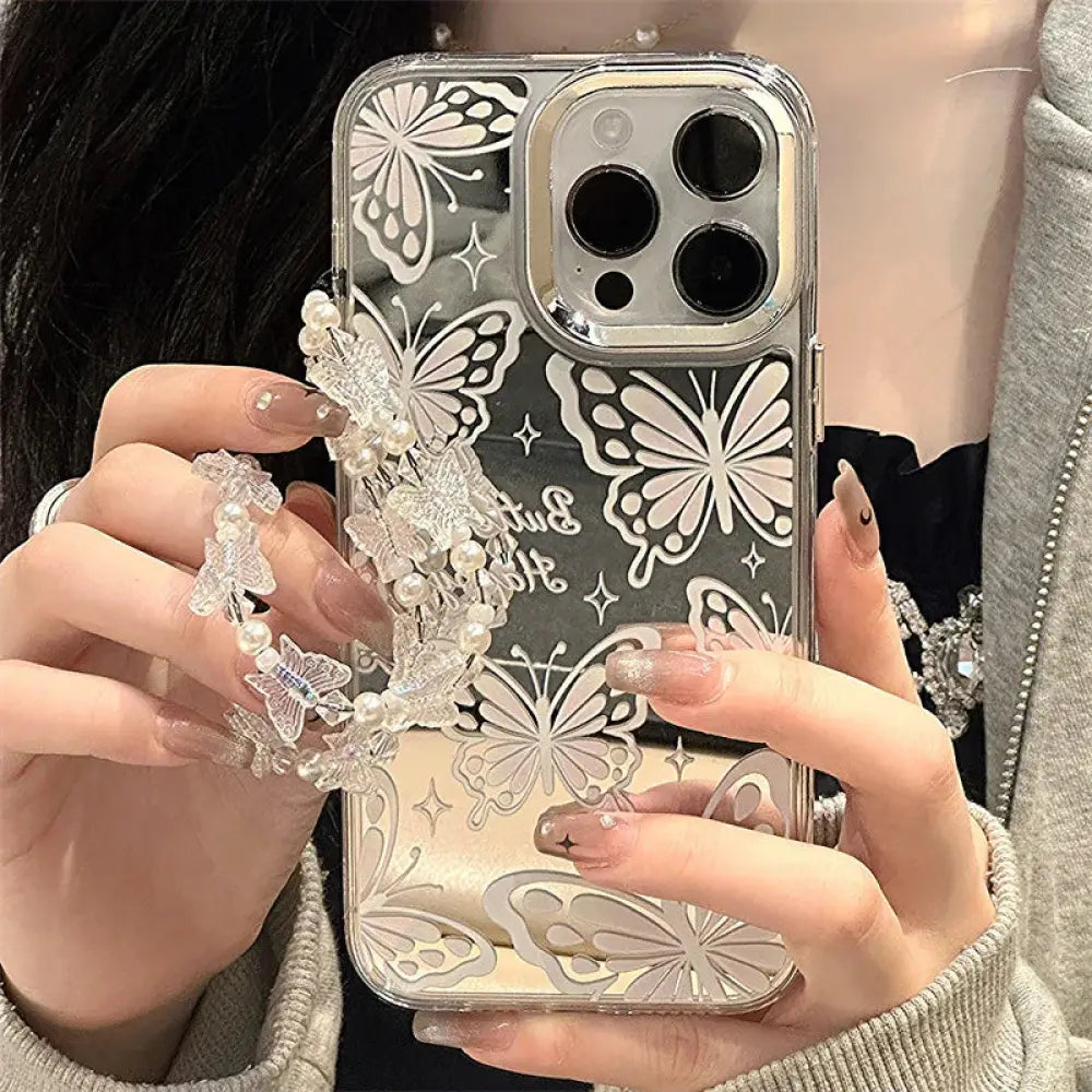 Clear butterfly mirror iphone 15 pro max protective case back with white butterfly cutouts and pearl embellishments