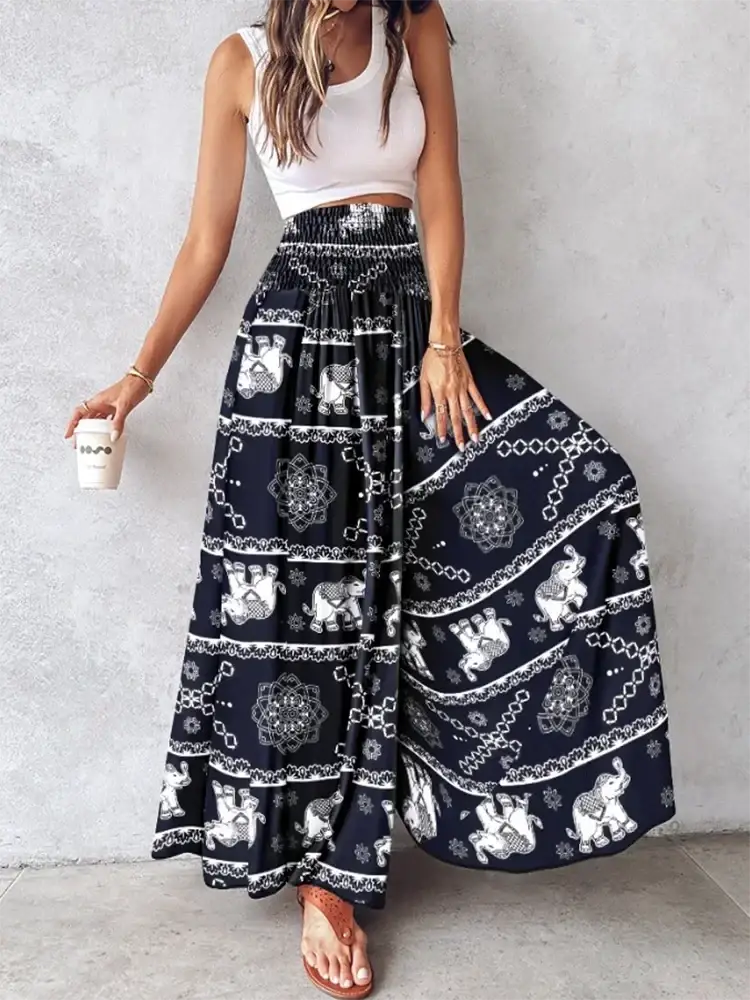Black wide leg pants featuring white elephant and mandala tie dye patterns in a flowy maxi skirt style