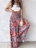 Colorful tie dye wide leg pants featuring a vibrant mandala pattern in reds blues and pinks with flowing fabric