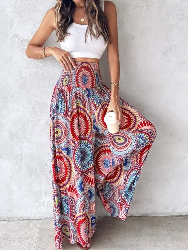 Colorful tie dye wide leg pants featuring a vibrant mandala pattern in reds blues and pinks with flowing fabric