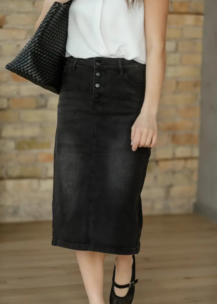 Black denim midi skirt with button front and rolled hem featuring high waisted design for stylish casual wear