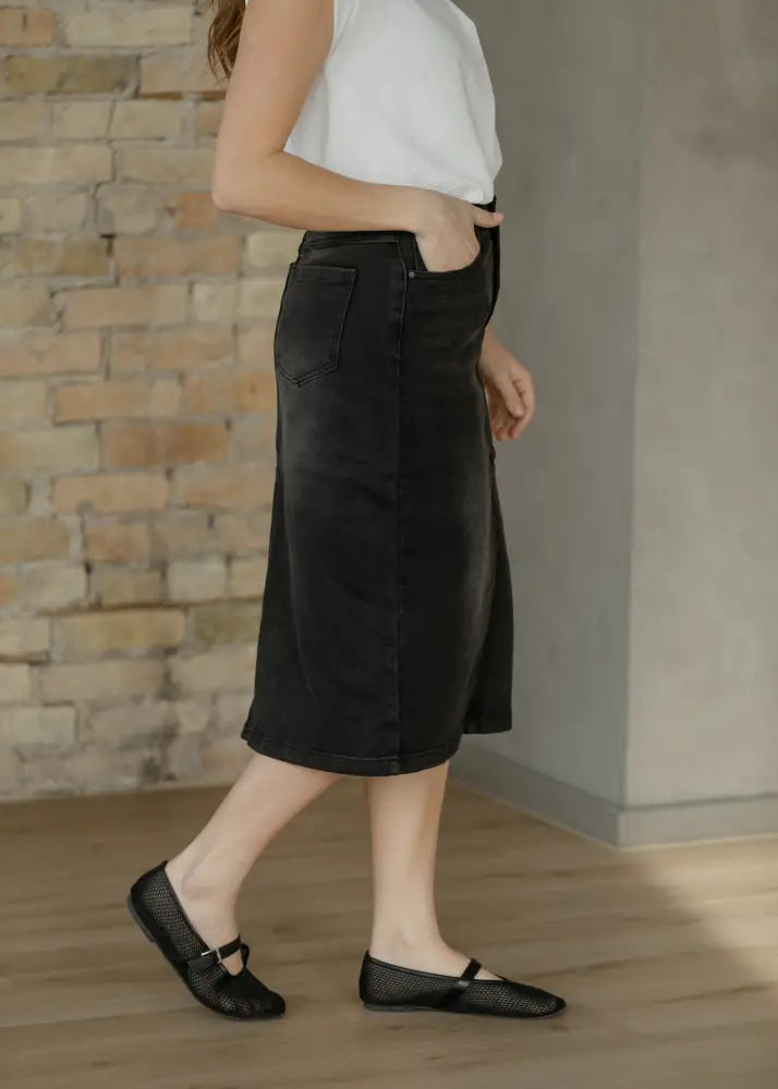 Black denim midi skirt with high waist button front, side slit, and front pockets for stylish casual wear