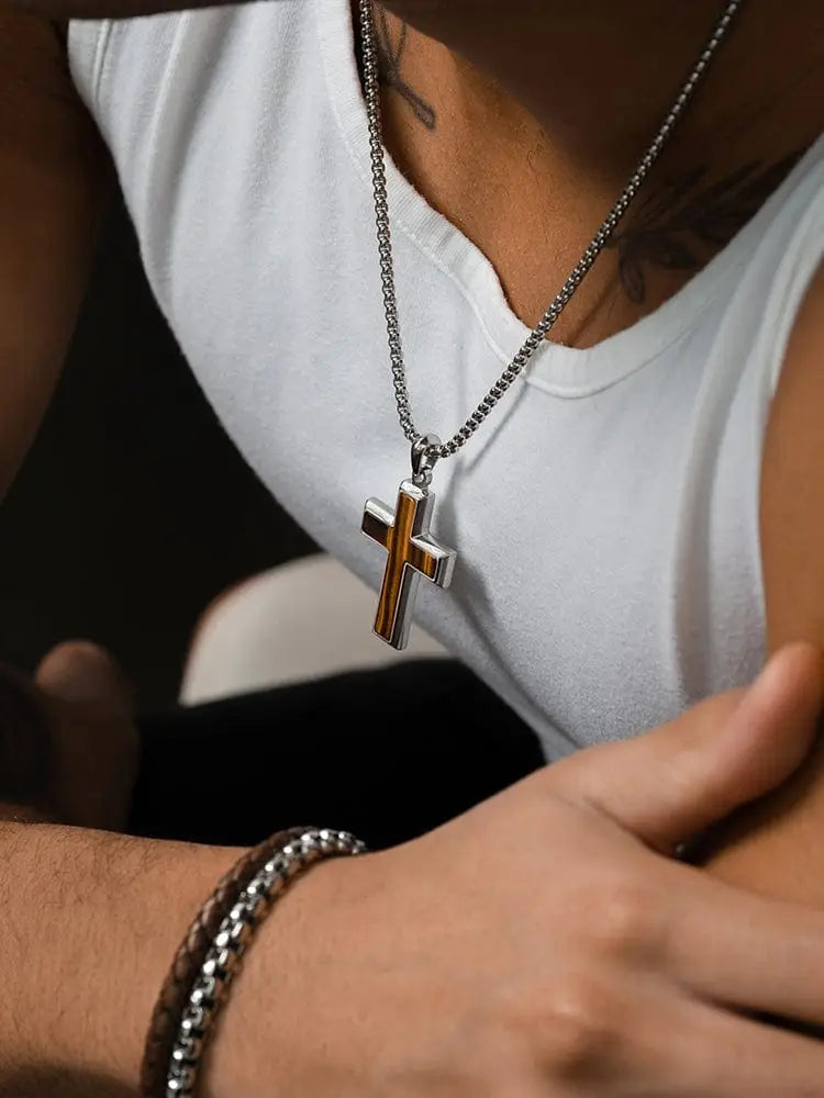 A sleek silver stainless steel cross pendant necklace with warm wood grain inlay hanging from a fine chain