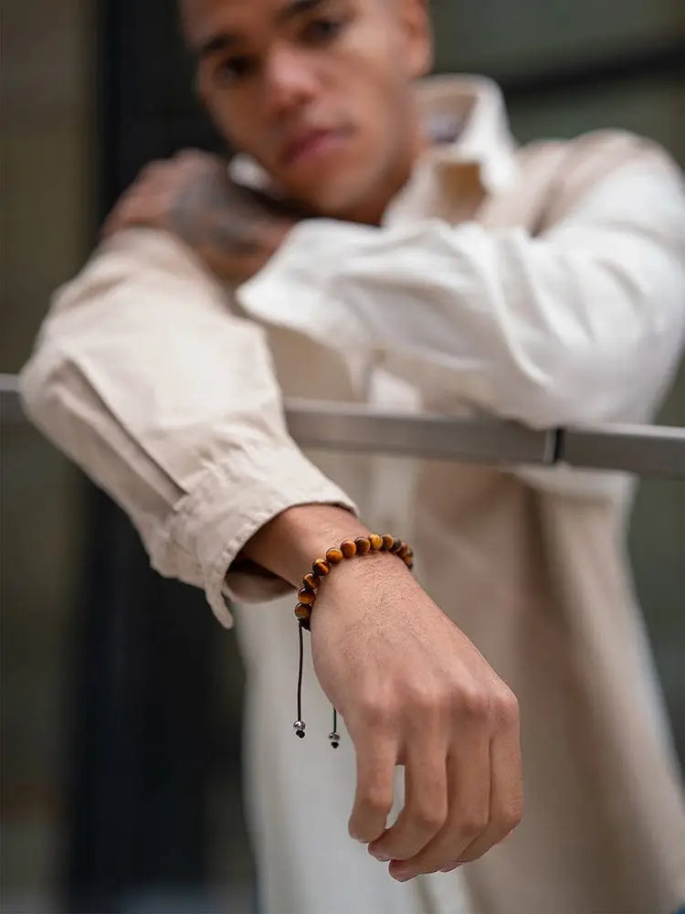 Adjustable Bali tiger eye beaded bracelet with black cord and silver toned stainless steel toggle clasp