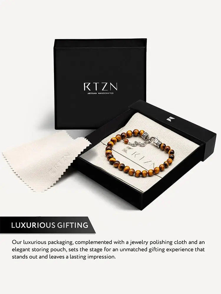 A sleek handcrafted tiger eye beaded bracelet with silver chain clasp in an elegant black rtzn gift box
