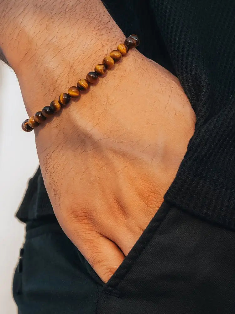 Tiger eye beaded bracelet with silver chain clasp featuring sleek round beads in natural brown and golden hues