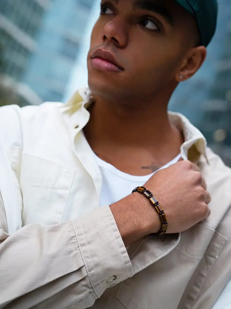 A stylish havana tiger eye beaded bracelet with gold accents in brown and black worn on a wrist
