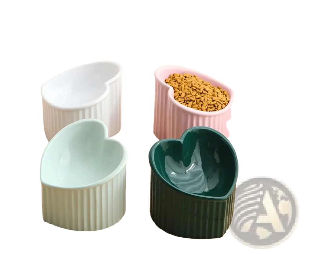 Set of four heart-shaped ceramic pet bowls in white pink mint green and dark green with vertical ribbed sides