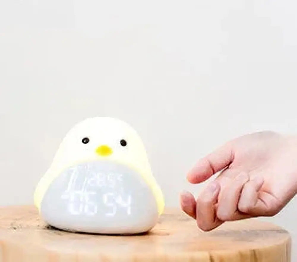 Time bird smart penguin digital clock and night light is a cute white and yellow plush chick led night light with time display