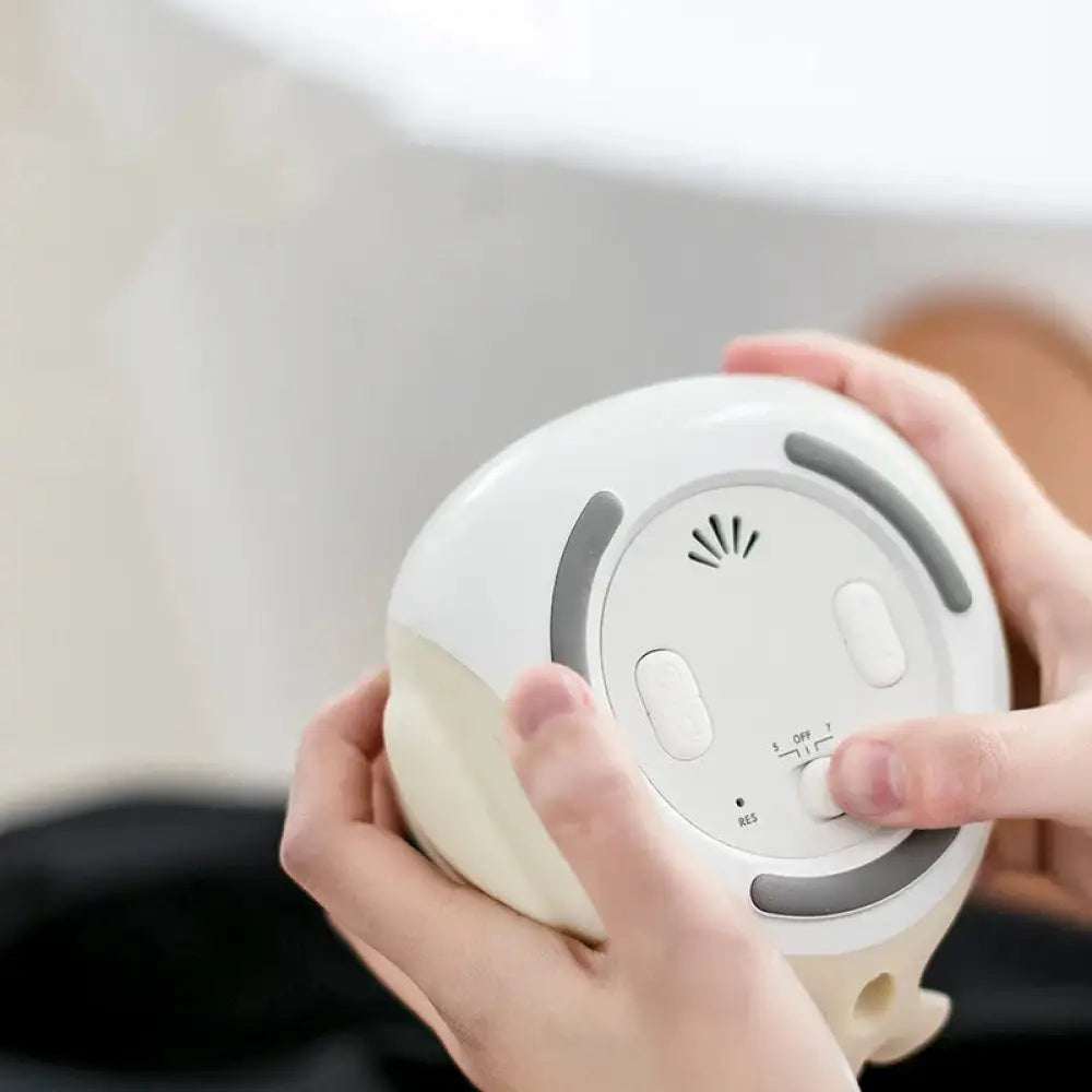 White and beige silicone breast pump with gray buttons and speaker grille for the time bird smart penguin digital clock and night light