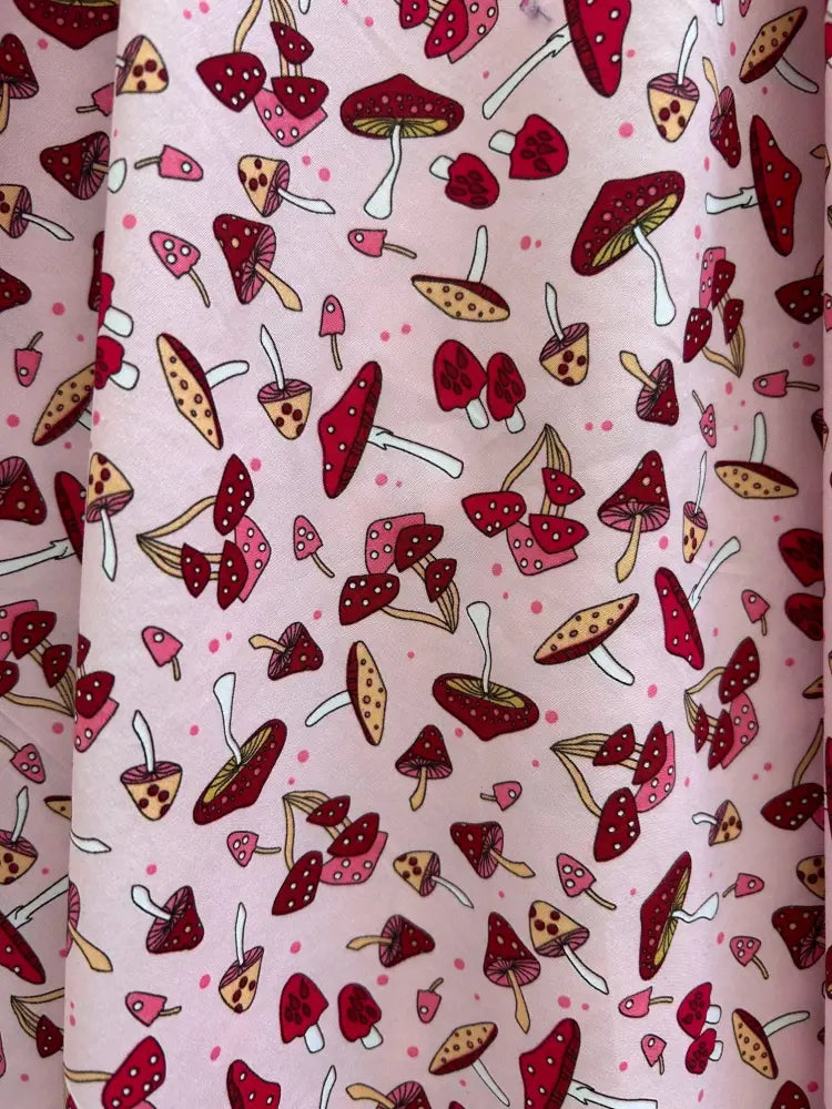 Pink cotton 1950s vintage A-line dress with playful red and beige toadstool print and white polka dot stems