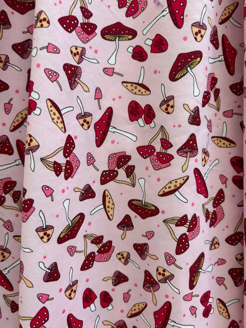Pink cotton 1950s vintage A-line dress with playful red and beige toadstool print and white polka dot stems