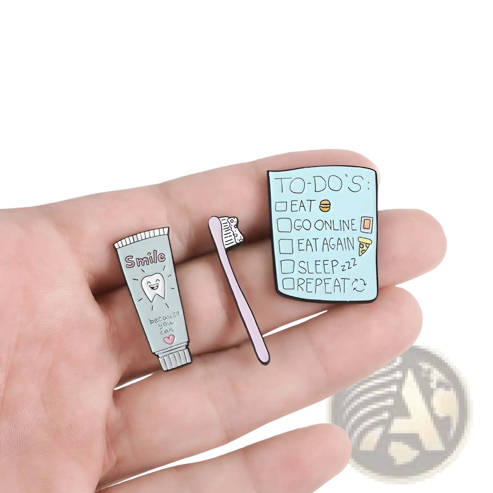 Three enamel pins featuring a cartoon toothpaste smile, pink toothbrush, and light blue checklist for dental care