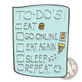 Light blue enamel pin shaped like a to-do list with black text and food icons from toothpaste smile collection