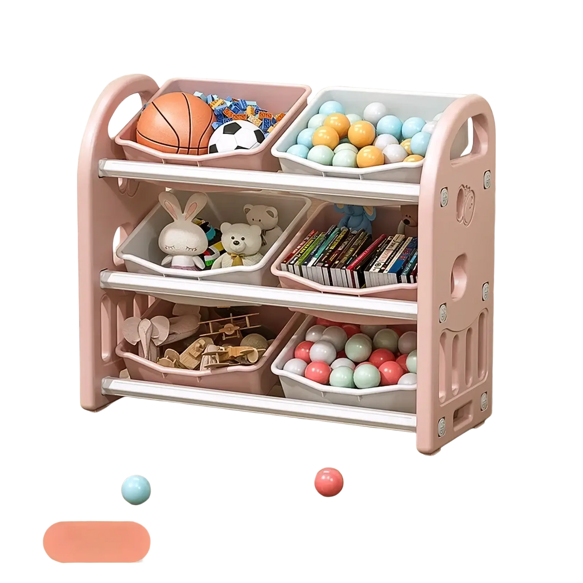 Pink plastic toy storage cabinet with white-trimmed compartments holding balls books and stuffed animals