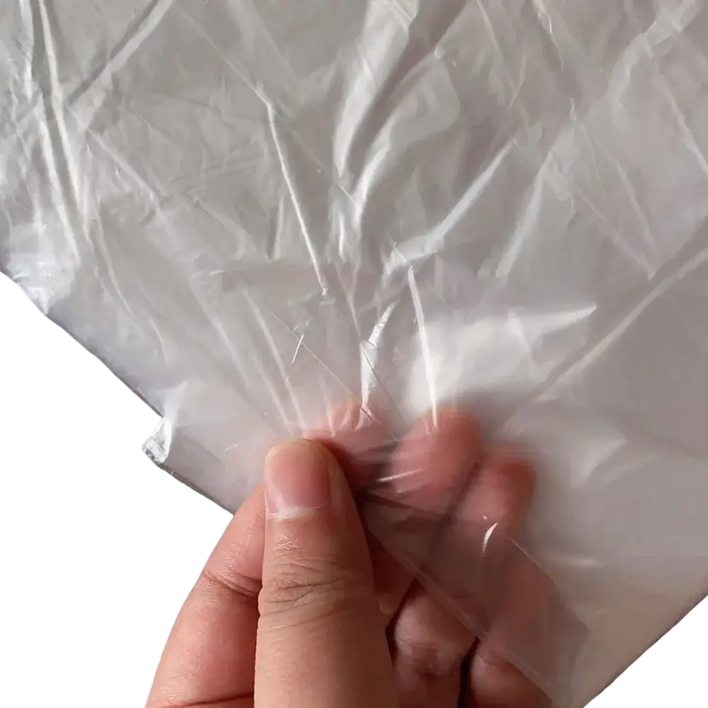 Clear transparent plastic furniture dust cover film with crinkled texture and sealed edge held by a hand