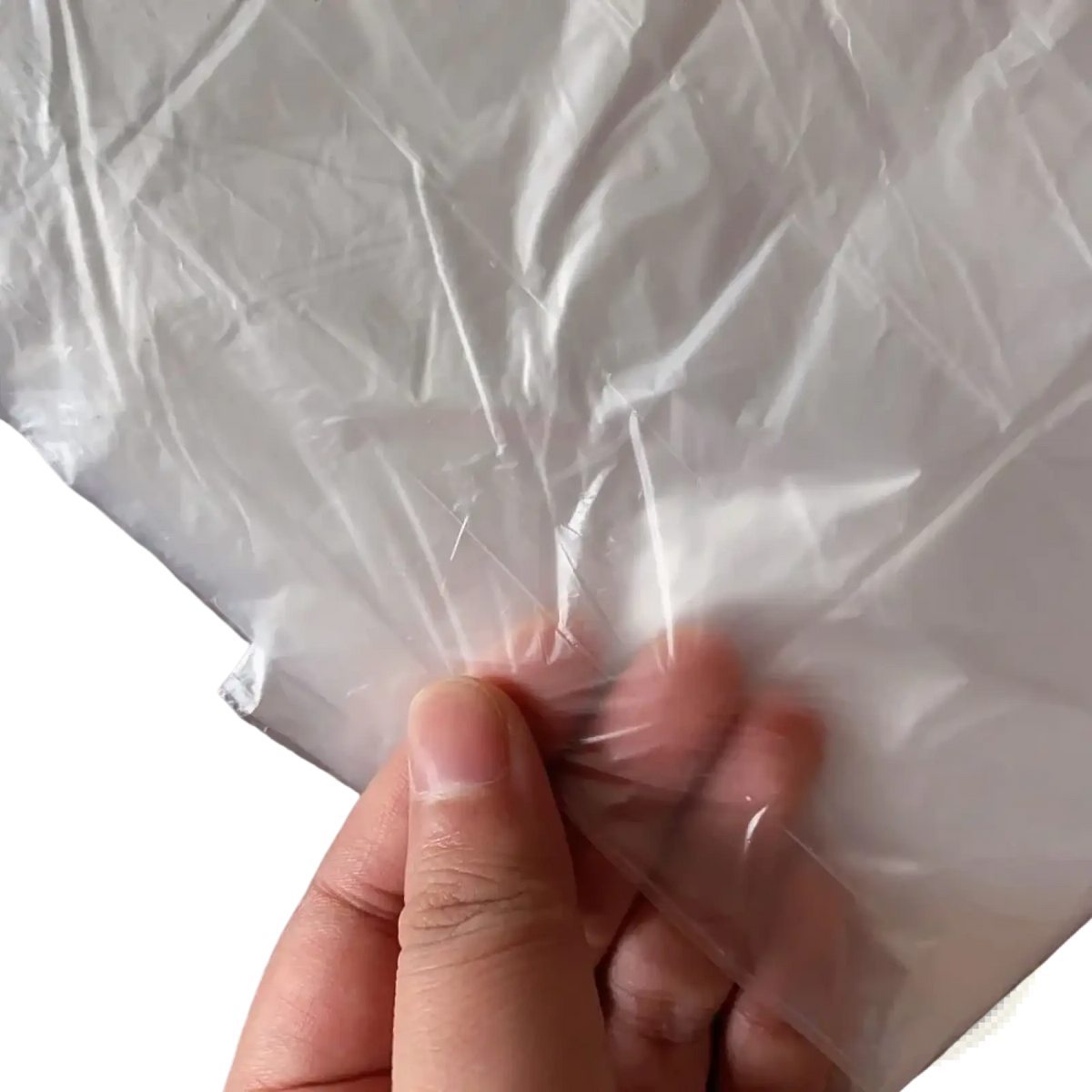 Clear plastic furniture dust cover protection film with crinkled texture and sealed edge held by a hand