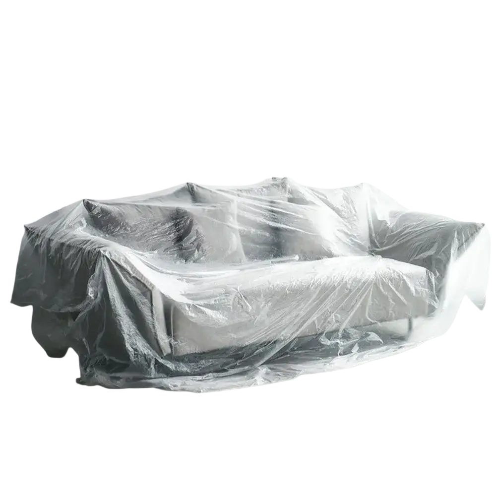 A transparent plastic furniture dust cover protector draped over a gray upholstered sofa for protection