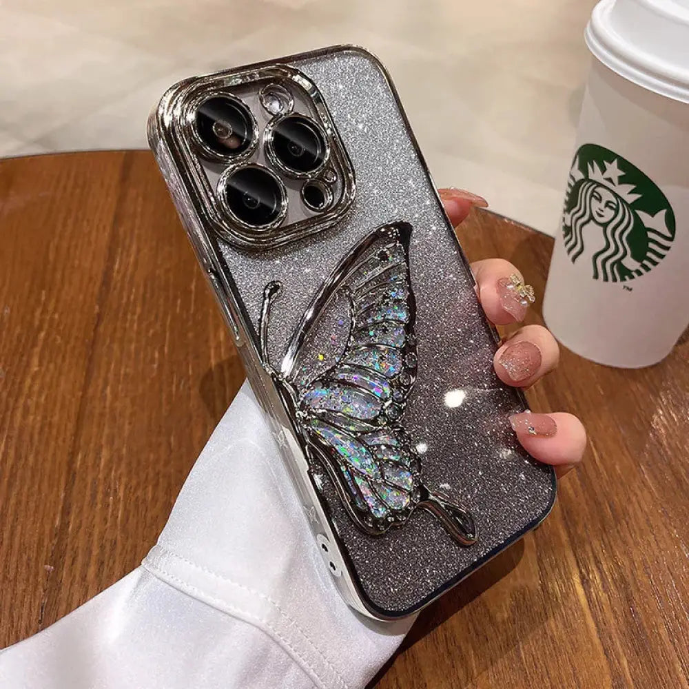 Back side of a sparkling silver glitter shatterproof quicksand phone case with an iridescent butterfly crystal embellishment