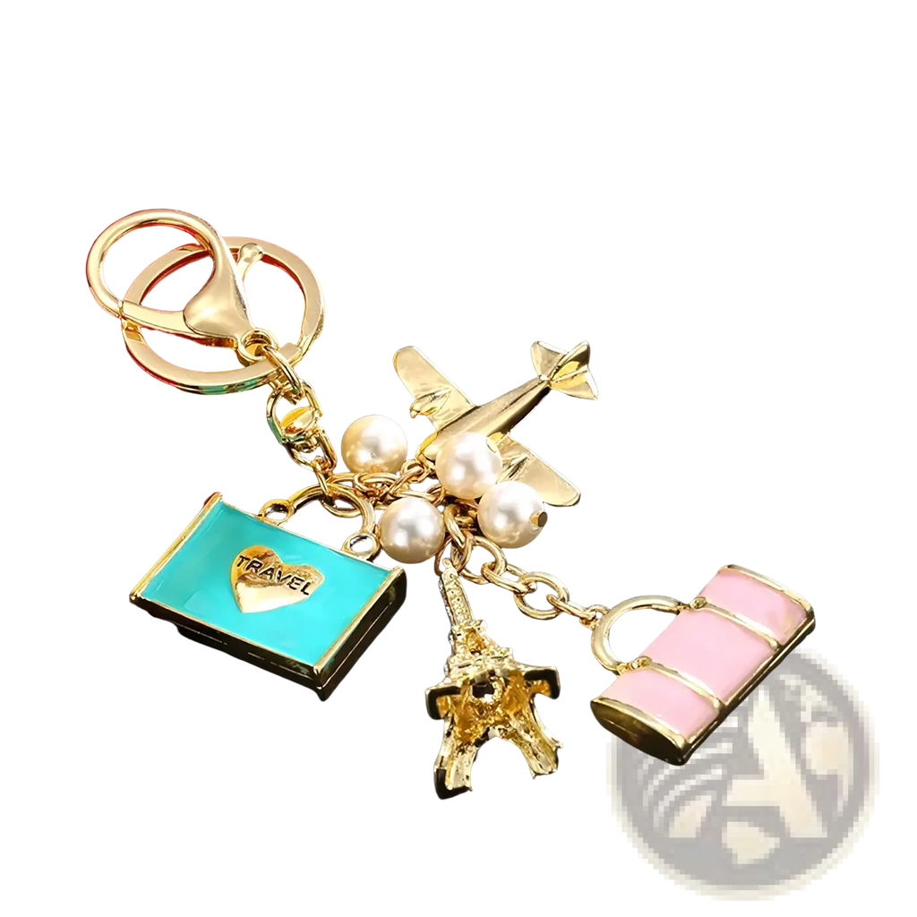 Gold-toned travel keychain with airplane Eiffel Tower pink suitcase turquoise travel tag and white pearls handbag charm