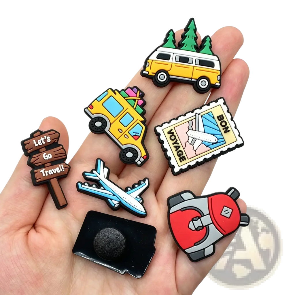 A hand holds colorful travel-themed travel shoe charms pvc clog decorations featuring van airplane and backpack designs