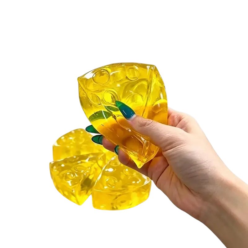 A translucent yellow mini triangle cheese fidget toy made of gelatinous material for soft stress relief and squeezing