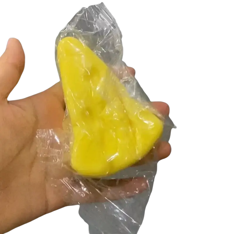 Yellow cheese-shaped slow rising squishy toy in clear plastic packaging from 12-piece triangle cheese set