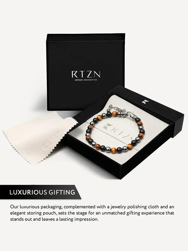 A stylish triple protection tiger eye and obsidian chain bracelet with alternating tiger eye and black onyx stones and a silver clasp