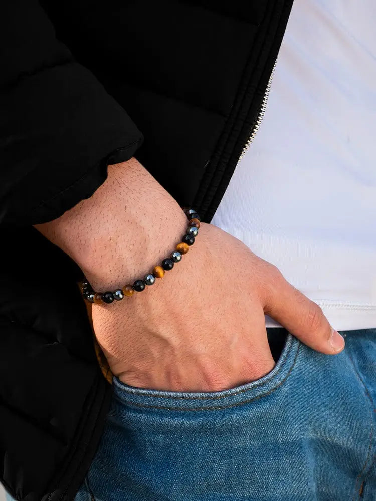 A men’s beaded bracelet featuring alternating tiger eye and black onyx stones in a simple chain design