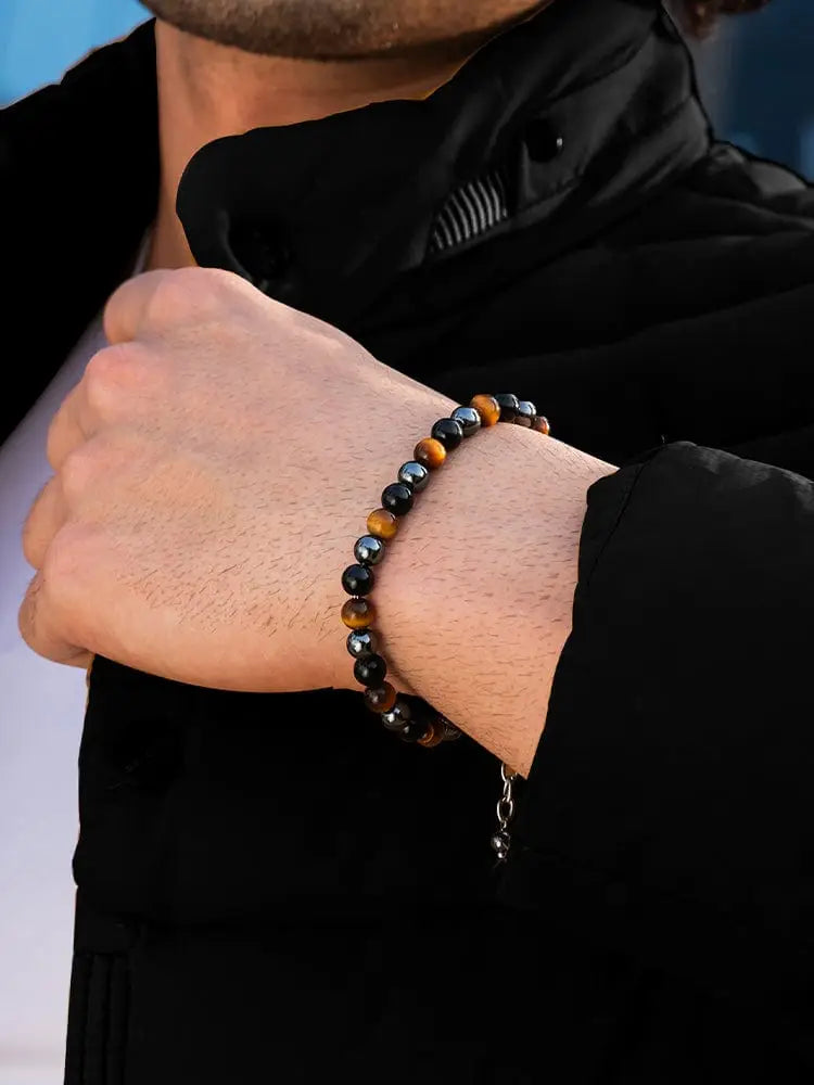 A stylish triple protection tiger eye and obsidian chain bracelet with alternating stones and a silver charm