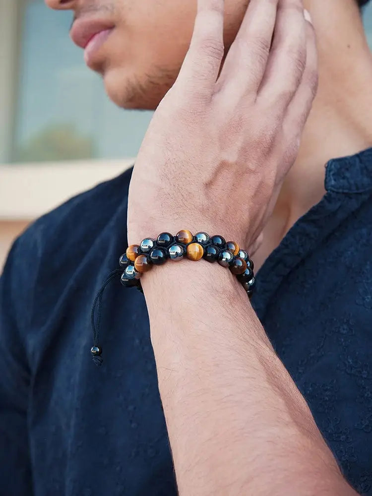 A triple protection tiger eye beaded bracelet with alternating black and golden beads and an adjustable cord