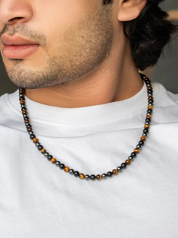 A men’s triple protection tiger eye and hematite beaded necklace with alternating brown orange and dark metallic spheres