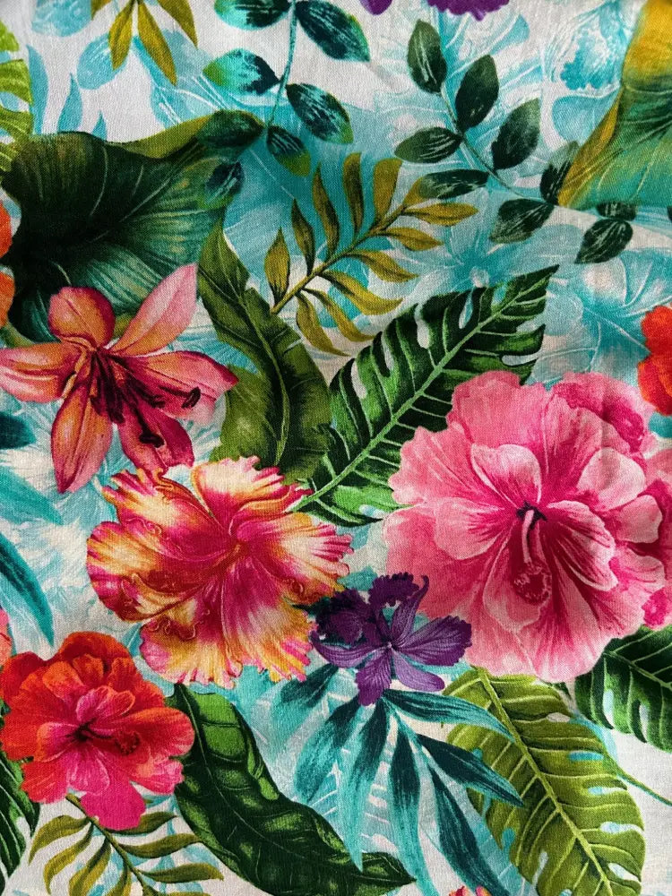 Tropical floral retro fit and flare cotton midi dress with vibrant pink red purple blossoms and green leaves on light blue