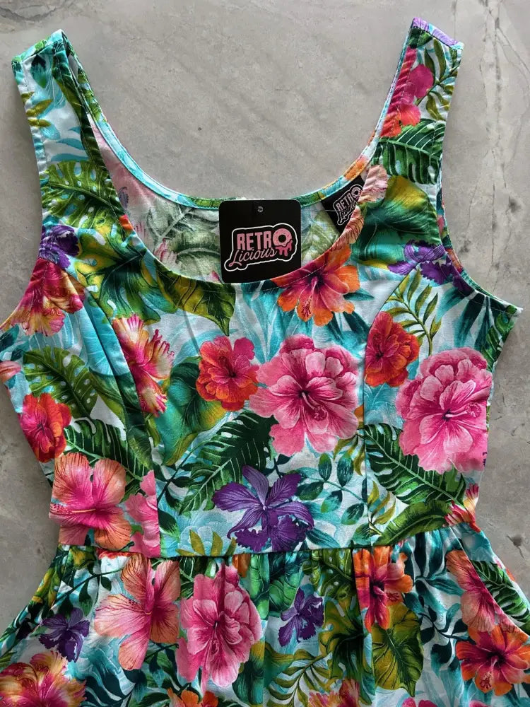 A tropical floral retro fit and flare cotton midi dress with vibrant pink orange and purple hibiscus on light blue