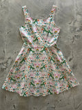 Tropical flamingo and alligator print sleeveless skater dress with fitted bodice and flared skirt on cream background