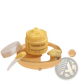 A yellow turmeric face cream in a clear glass jar with white lid labeled lanthome organic brighten skin with ginger slices