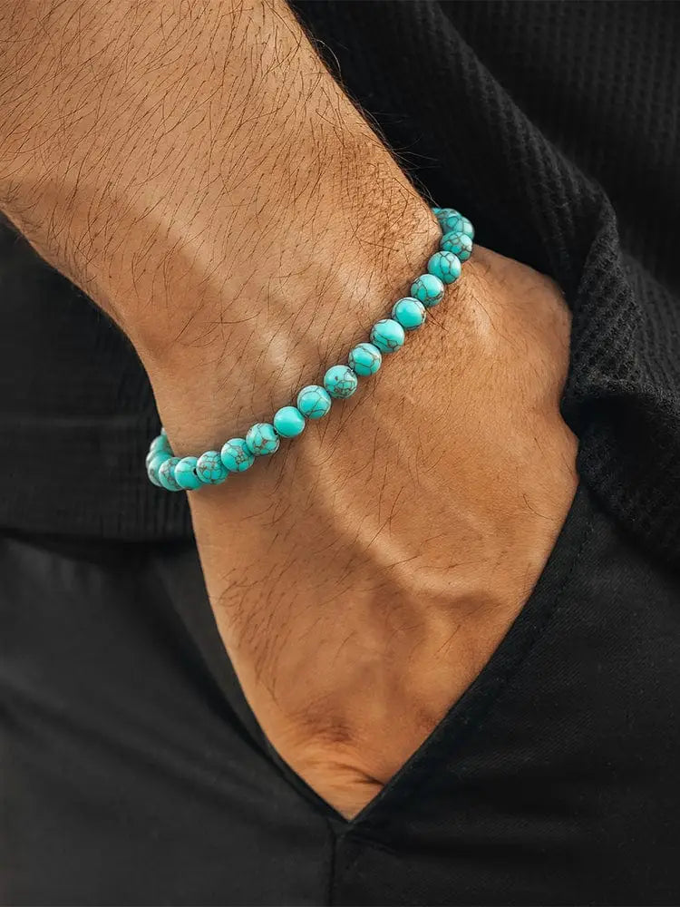 Authentic turquoise stone beaded bracelet with silver clasp featuring smooth rounded turquoise beads worn on an arm