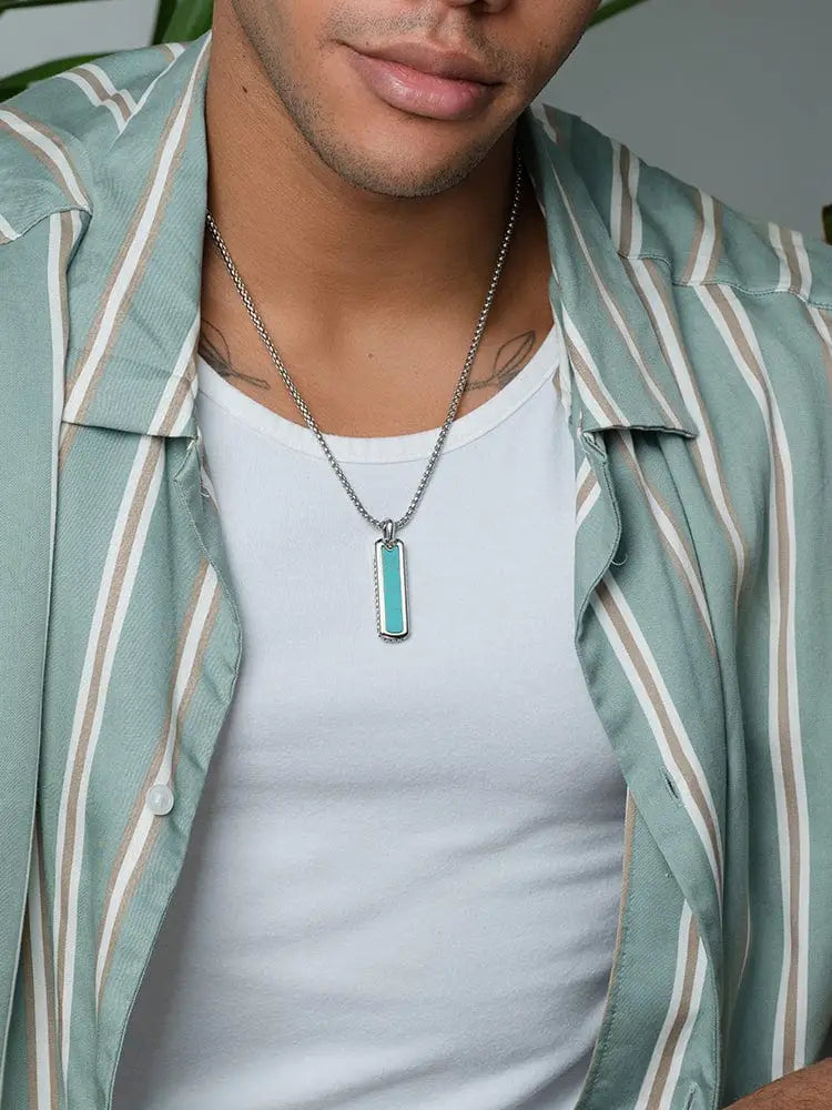 A sleek silver stainless steel box chain necklace with a rectangular turquoise pendant featuring beveled edges