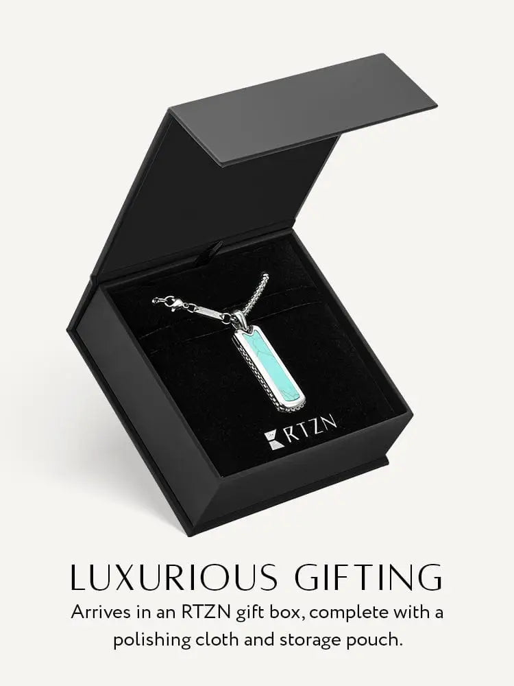 A sleek silver men’s stainless steel pendant necklace with a rectangular turquoise inlay in a black gift box