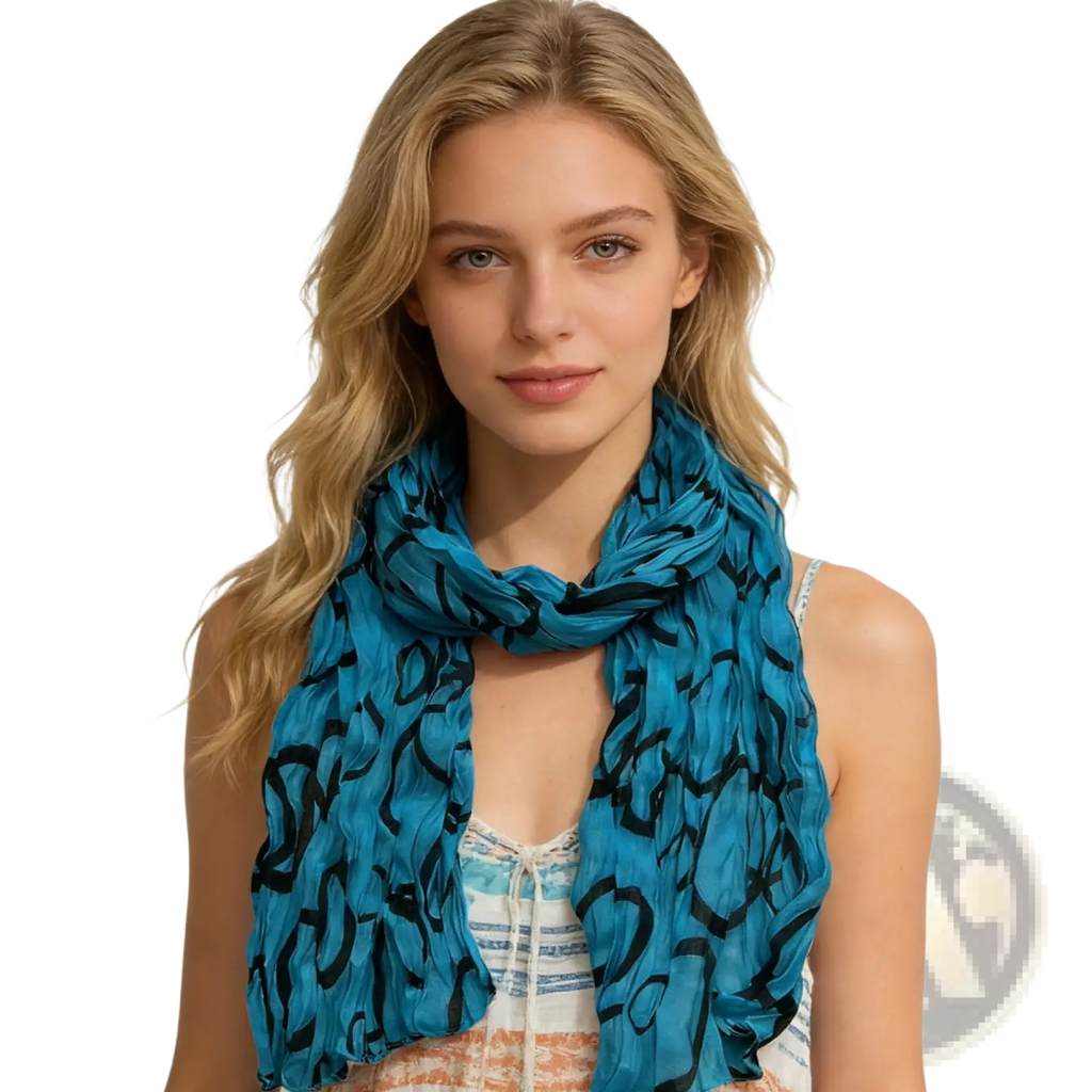 A flowing turquoise crinkle beach cover up scarf with bold black abstract pattern made of lightweight fabric