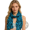 A flowing turquoise crinkle beach cover up scarf with bold black abstract pattern made of lightweight fabric