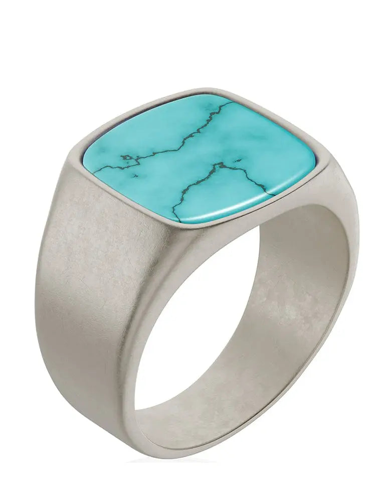 A sleek oxidized turquoise cushion signet ring in stainless steel featuring a square-cut turquoise stone with black veining