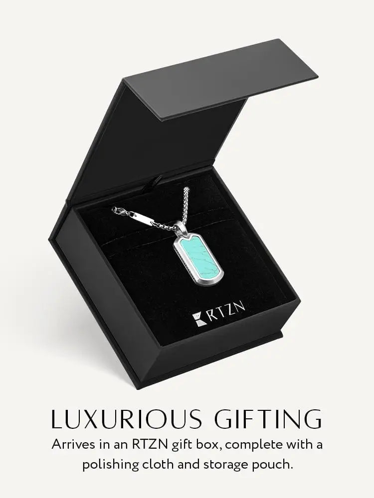 A silver stainless steel dog tag necklace with turquoise inlay displayed in an rtzn gift box