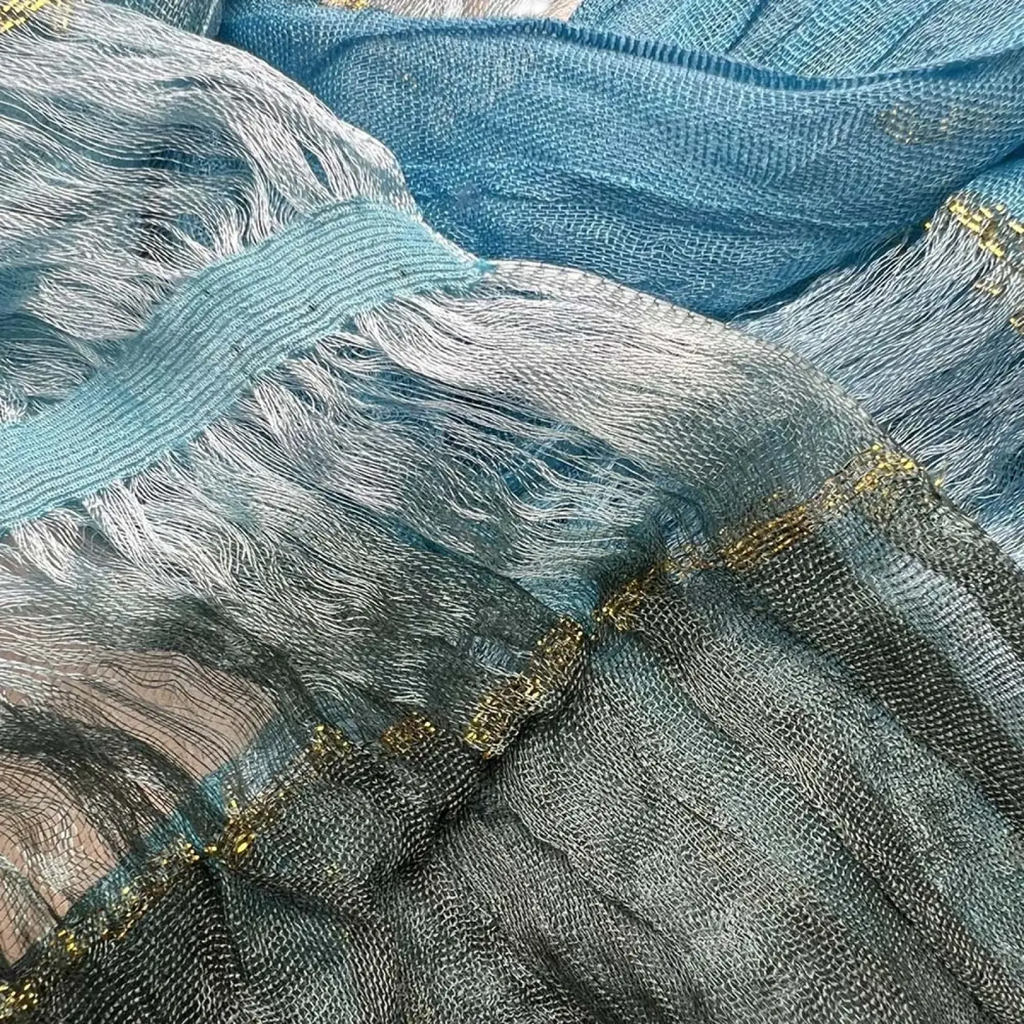 A delicate turquoise metallic skinny scarf with sheer blue silver mesh gold-trimmed edges and flowing fringe