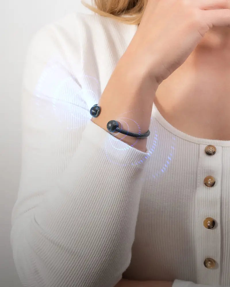 Black gunmetal twisted cable neodymium magnetic cuff bracelet with two spherical ends displayed on the back side