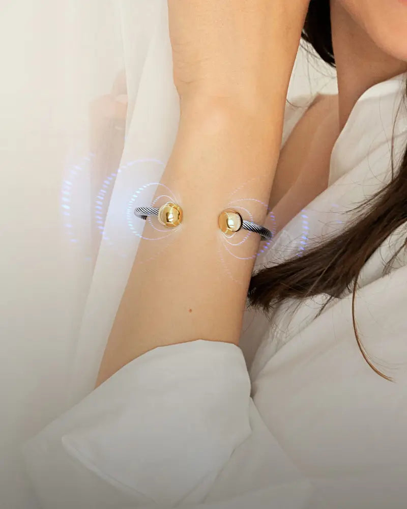 Twisted cable magnetic cuff bracelet in silver and gold featuring gold-toned spherical beads on a dark gray braided cord