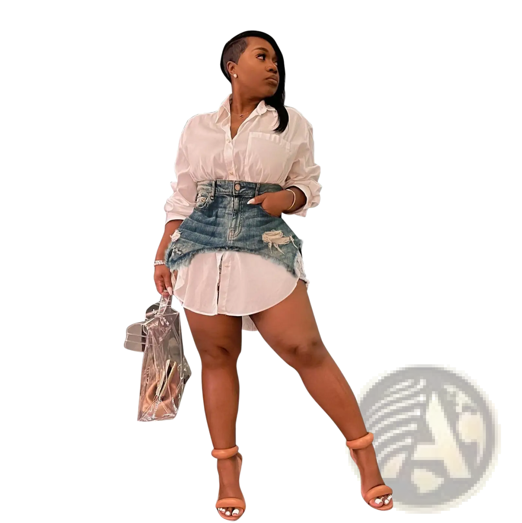 Woman wearing a two piece denim mini skirt and white button up shirt set holding a clear plastic handbag
