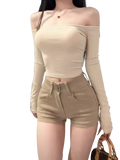 Beige off-the-shoulder long sleeve crop top with fitted stretchy fabric from two-piece set with high-waisted shorts